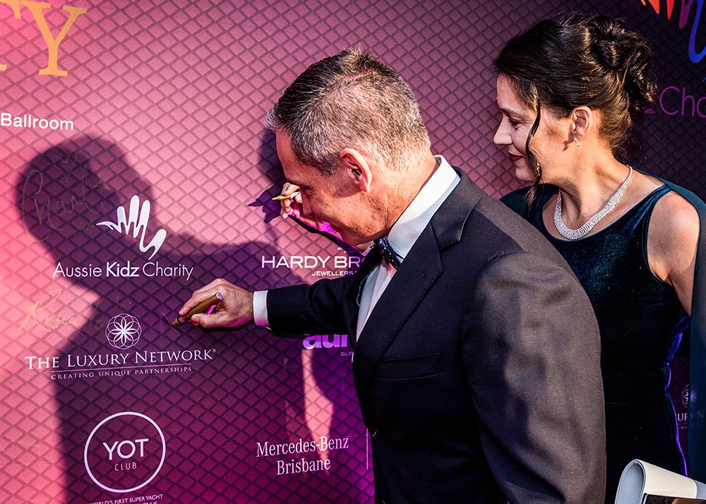 Paul Treloar from The Luxury Network signing the Media Wall at the Aussie Kidz Charity Gala in Brisbane